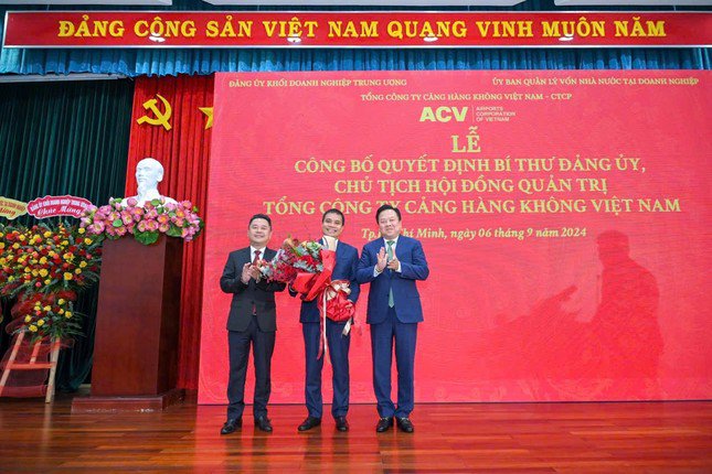 Tân chủ tịch ACV Vũ Thế Phiệt (giữa) nhận hoa chúc mừng từ lãnh đạo Ủy ban Quản lý vốn Nhà nước tại doanh nghiệp.