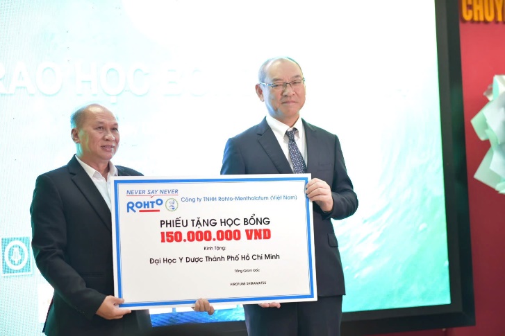 Ông Hirofumi Shiramatsu - Tổng giám đốc Rohto-Mentholatum Việt Nam (phải), tặng học bổng cho sinh viên khoa Dược trường Đại học Y Dược TP.HCM.