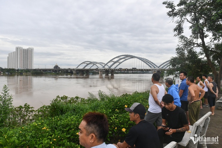 Nhiều người dân quanh vùng tại quận Long Biên đổ ra bờ sông quan sát nước tràn về từ thượng nguồn với tâm trạng lo lắng. Với nhiều thanh niên trẻ tuổi, đây là lần đầu tiên họ nhìn thấy cảnh này. Với những người con quê gốc huyện Gia Lâm sinh ra ở thập kỷ 50, 60 thì năm 1971 là trận lụt kinh khủng nhất và từng khiến họ phải leo lên nóc nhà để tránh lụt. Ảnh: Hoàng Hà