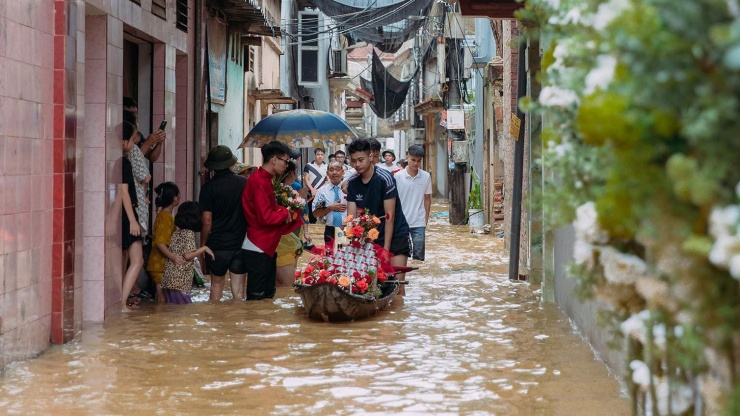 
Đoạn đường lội nước vào nhà gái khá xa nên dàn phù rể cũng phải dùng xuồng nhỏ chở tráp cưới. Các quan khách người ôm váy, người xắn quần vượt đoạn đường ngập tiến vào nhà gái. Dù khá gian nan vất vả nhưng ai nấy đều rạng rỡ, phấn khởi khi hộ tống chú rể đón cô dâu về nhà.