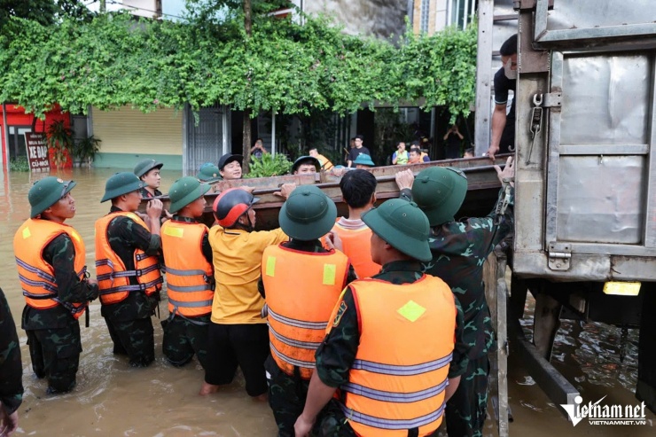 Bộ đội hạ thuyền máy để đẩy nhanh quá trình tiếp tế cho người dân vùng ngập. Ảnh: Lê Anh Dũng 