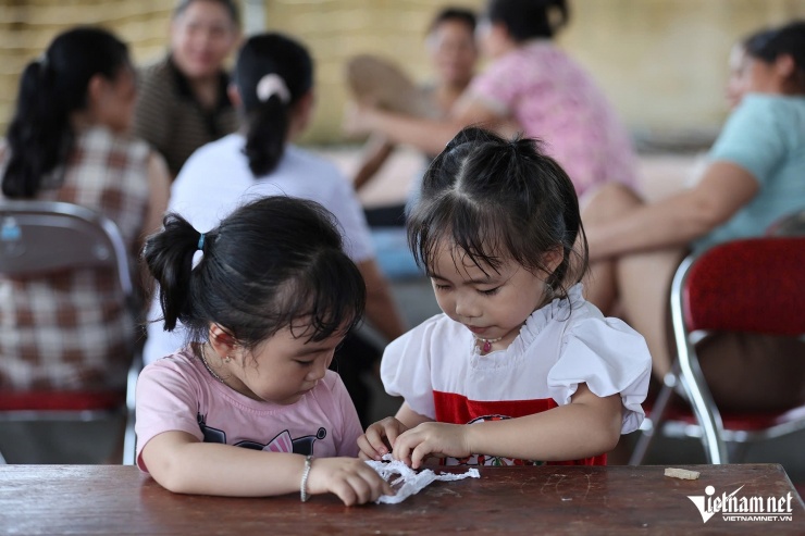 Người lớn, trẻ nhỏ đang tránh lũ tại nhà văn hoá thôn Tiên Phong. Ảnh: Lê Anh Dũng 