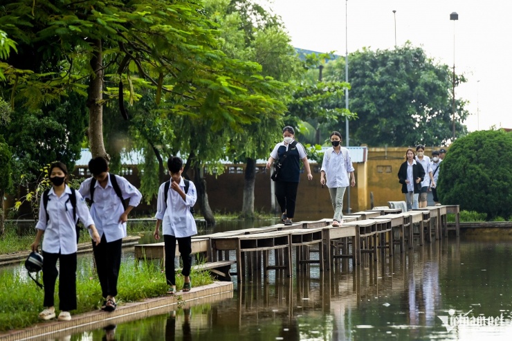 Dưới sân trường vẫn ngập sâu, việc di chuyển của học sinh vào lớp học gặp nhiều khó khăn. Do có vị trí tại khu vực thấp trũng, nhà trường xác định nước sẽ rút rất lâu nên để học sinh không phải lội nước vào lớp học, các thầy cô nghĩ ra phương án dùng ghế đá và các bàn học cũ đang lưu trữ trong kho, tận dụng làm 