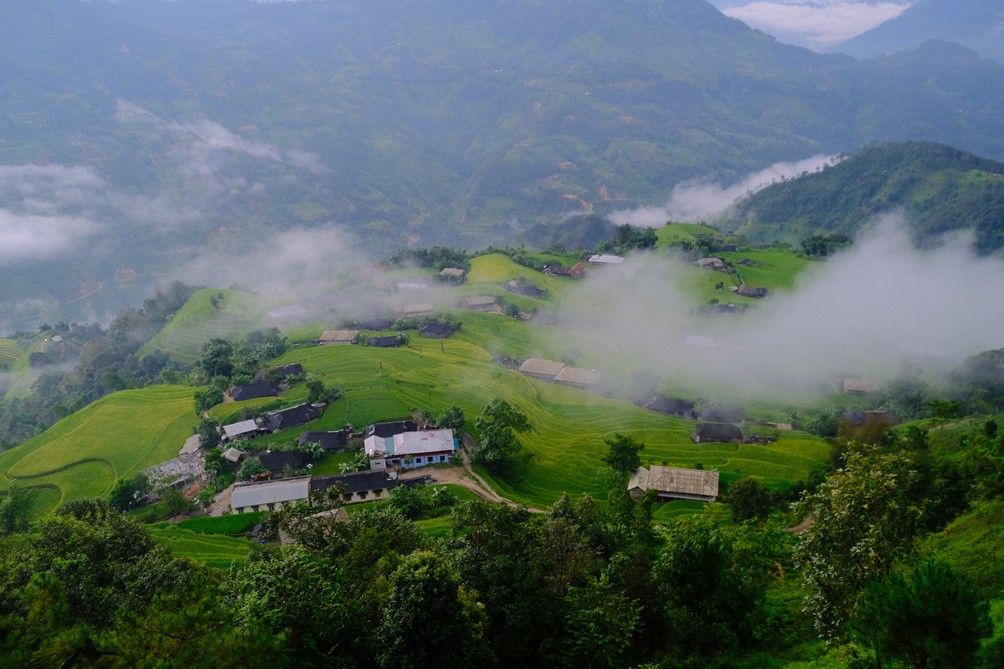 Những làn khói lam chiều phủ mờ trên những ngôi nhà nhỏ xa xa, tạo nên khung cảnh yên bình và có chút cô liêu.