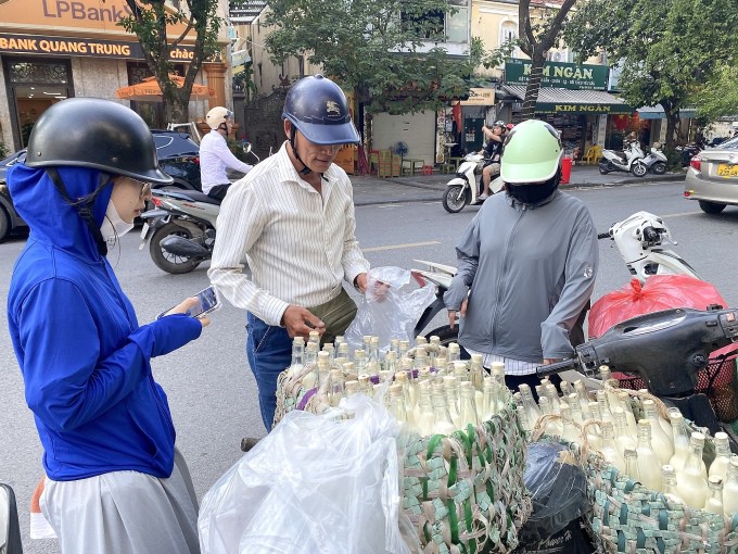 Anh Phạm Văn Tiến, 60 tuổi, bán sữa đậu nành đựng trong chai thủy tinh nút bằng lõi bấc cho khách trên phố Quang Trung, quận Hoàn Kiếm, chiều 18/9. Ảnh: Quỳnh Nguyễn