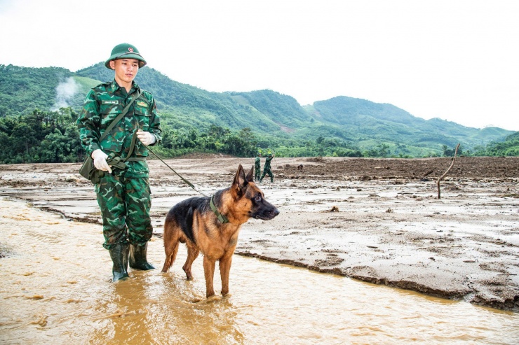 Thiếu úy Xồng Bá Lành động viên con Nam Da vào những thời điểm mưa, bùn lầy ngập ngụa . Ảnh: Văn Chương