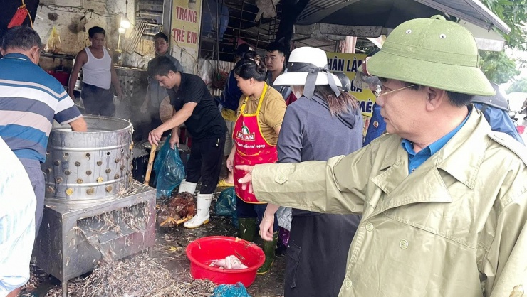 Ông Chu Văn Mai - Chủ tịch UBND xã Nghi Ân chỉ đạo mọi người cùng chung tay giải cứu đàn gà bị chết ngạt. Ảnh: CTV