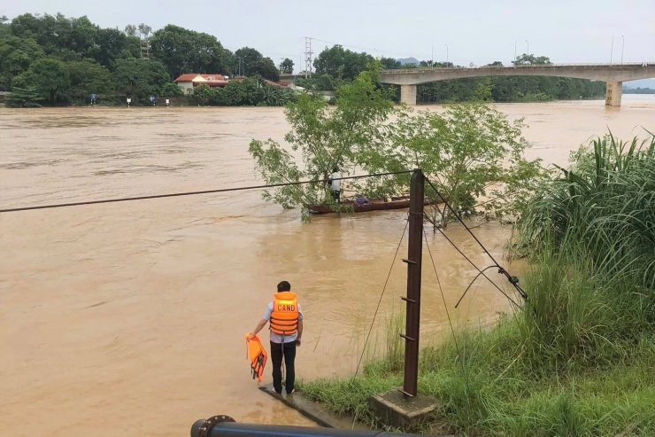 Lực lượng chức năng cứu người đàn ông mắc kẹt trên cành cây. Ảnh: CTV