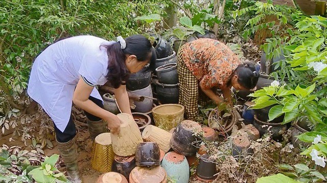 Cán bộ y tế huyện Phú Xuyên (Hà Nội) hướng dẫn người dân vệ sinh môi trường tại hộ gia đình phòng ngừa sốt xuất huyết. Ảnh TL