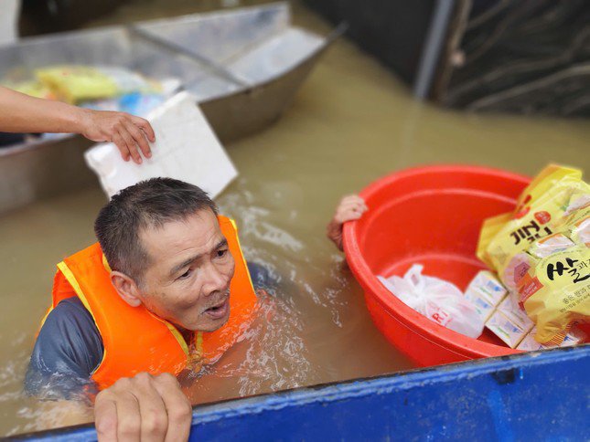 Khoảnh khắc cụ già 70 tuổi bơi trong dòng nước lũ cao hơn 2 mét để lấy hàng cứu trợ cho cháu mình.