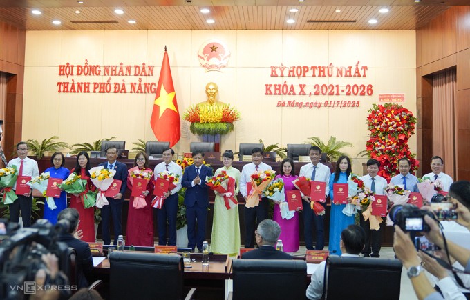 Ông Lương Nguyễn Minh Triết, Chủ tịch UBND TP Đà Nẵng, trao quyết định và tặng hoa cho 14 lãnh đạo sở, ngành, sáng 1/7. Ảnh: Nguyễn Đông