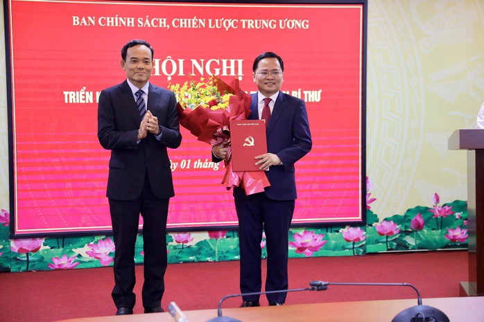 Ông Trần Lưu Quang, Bí thư Trung ương Đảng, Trưởng Ban Chính sách, chiến lược Trung ương (bên trái), trao quyết định cho ông Nguyễn Anh Tuấn. Ảnh: Thành Trung