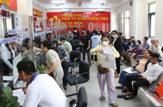 Rất đông người dân đến Trung tâm hành chính công xã Bà Điểm để làm thủ tục trong ngày đầu sáp nhập, thực hiện chính quyền hai cấp. Ảnh: Đình Văn