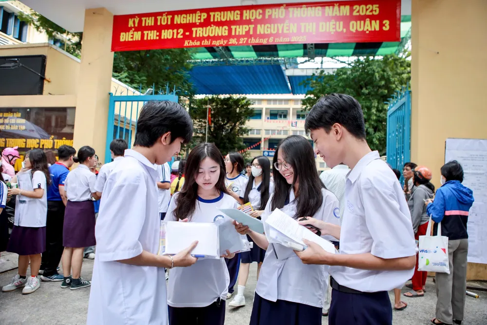 Thí sinh trao đổi bài sau khi kết thúc bài thi môn Văn. Ảnh: NGUYỆT NHI