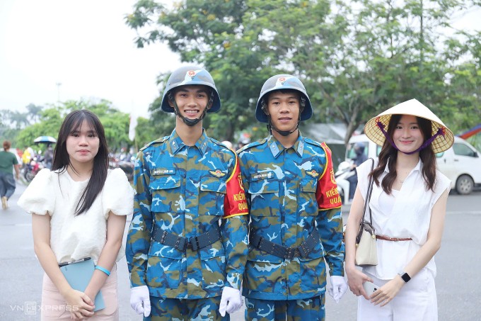 Nguyễn Thùy Linh, 22 tuổi (ngoài cùng bên phải) cùng em gái Ngọc Bích chụp ảnh cùng các chiến sĩ tại Làng Văn hóa các dân tộc Việt Nam, sáng 2/7. Ảnh: Quỳnh Nguyễn