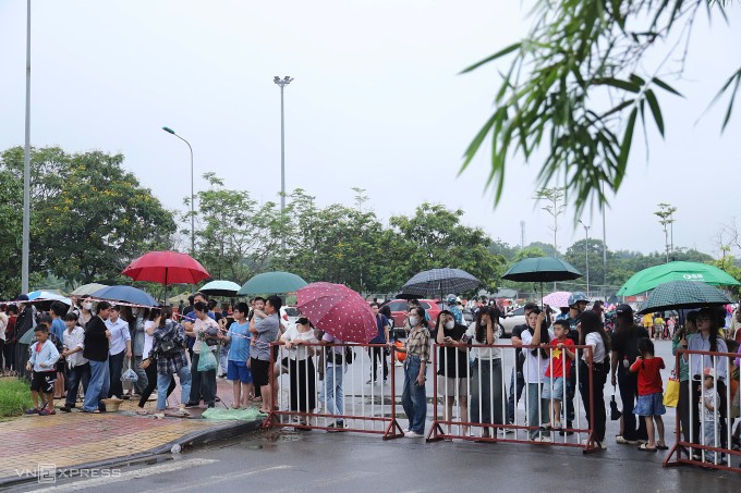 Người dân đội mưa đến xem các chiến sĩ hợp luyện tại Làng Văn hóa các dân tộc Việt Nam, sáng 2/7. Ảnh: Nga Thanh