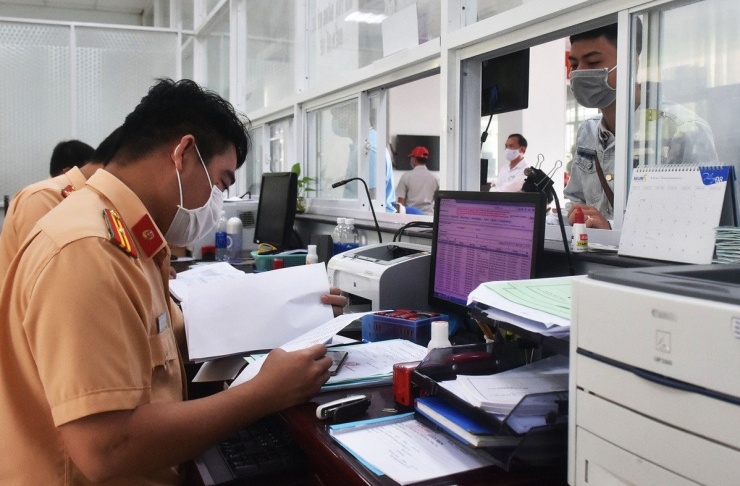 Cán bộ Phòng CSGT Công an tỉnh Bà Rịa - Vũng Tàu (cũ) xem xét hồ sơ cấp biển số xe ô tô cho người dân đến đăng ký. Ảnh: Văn Anh