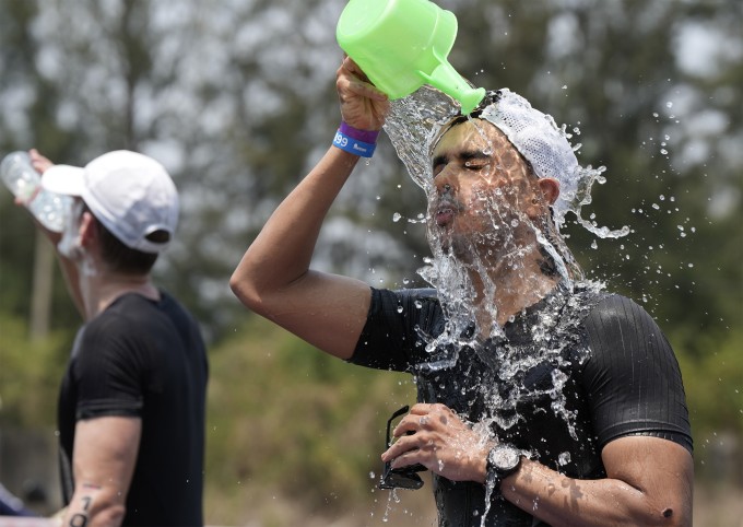 Vận động viên tham gia giải ba môn phối hợp tiếp nước trong thời tiết nóng bức, tháng 5/2024. Ảnh: Nguyễn Đông