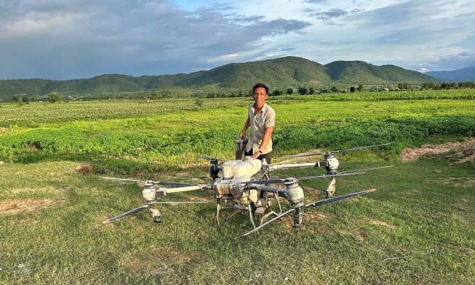Anh Trần Văn Nghĩa cùng drone ở ruộng khoai lang gần sông Ba. Ảnh: Ngọc Oanh
