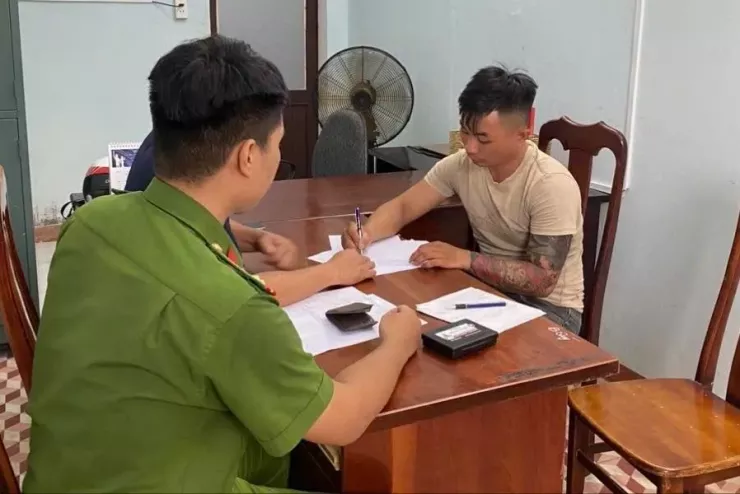 Kẻ cướp phục sẵn tại nhà vệ sinh, kề dao vào cổ yêu cầu nạn nhân đưa tiền. Ảnh: CA