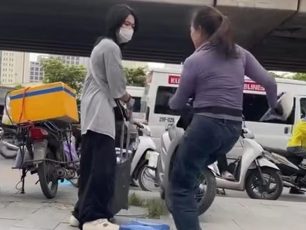 Người bán trà đá xua đuổi cô gái đứng ở vỉa hè bến xe Mỹ Đình (Ảnh: Cắt từ clip).