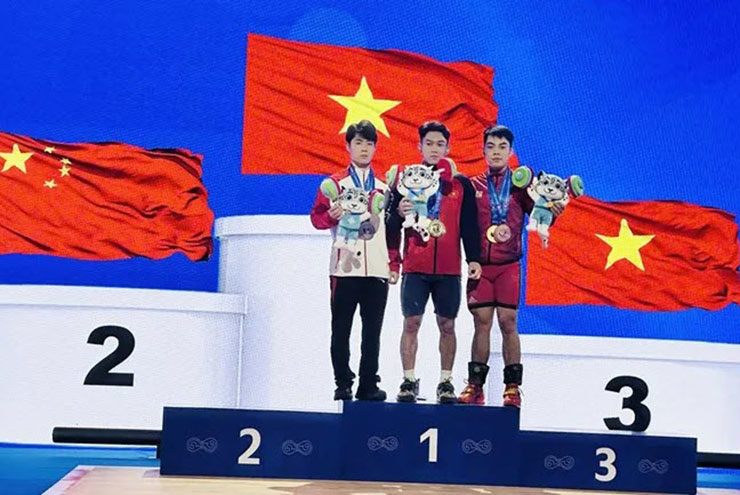 K'Dương (giữa) và Dương Tuấn Kiệt (phải) trên bục nhận huy chương tổng cử hạng cân 60kg nam