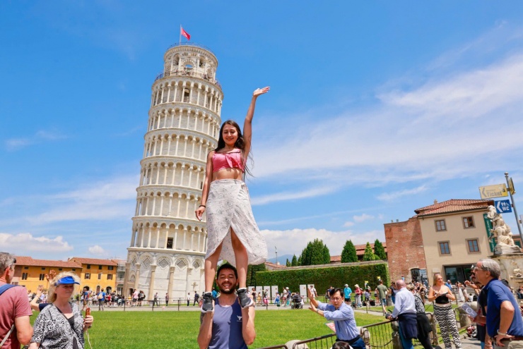 Du khách tạo dáng trước tháp nghiêng Pisa.