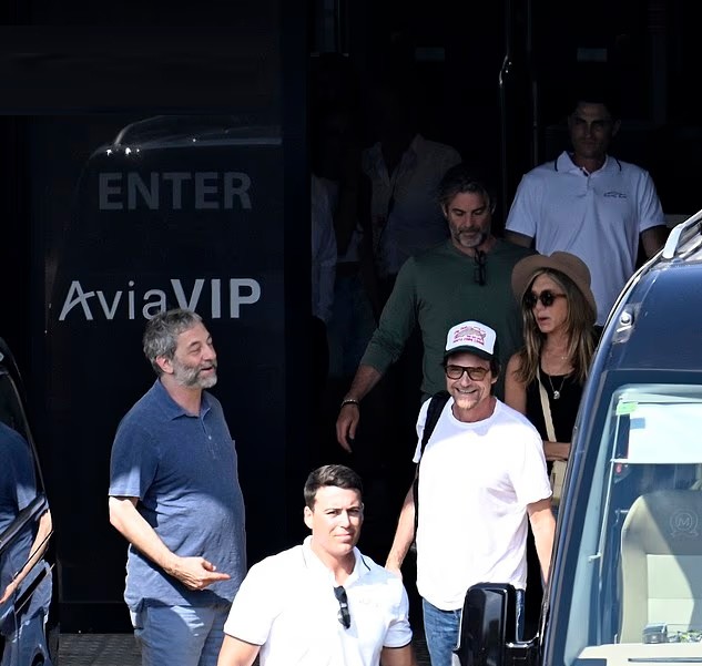 Jennifer Aniston và Jim Curtis (mặc áo phông xanh đi phía sau) tại Mallorca, Tây Ban Nha. Ảnh: Dailymail