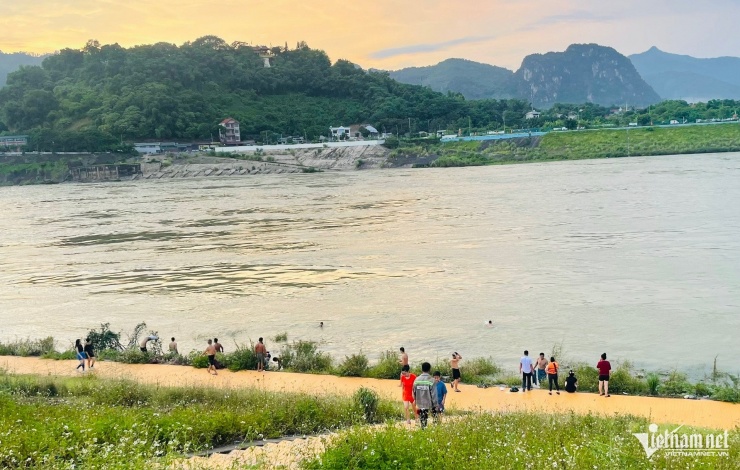 Một số người dân bơi lội dưới hạ lưu khi Thủy điện Hòa Bình xả lũ. Ảnh: Anh Tâm
