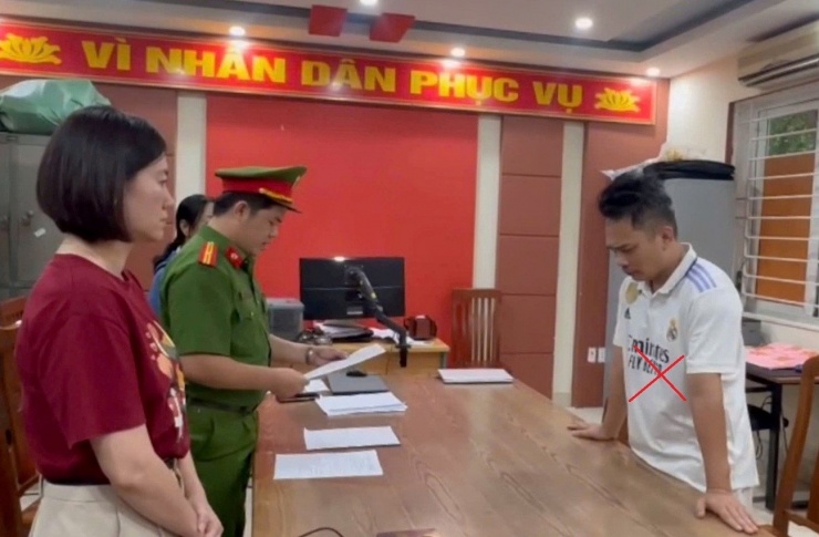 Nguyễn Thành Long (áo trắng) tại cơ quan công an.