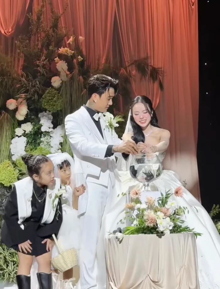 Đạt G và Cindy Lư nhỏ máu xuống cốc nước lớn trước sự chứng kiến của hai con. Ảnh: aimeebridal153.
