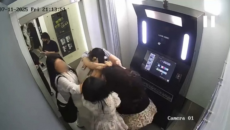 Hình ảnh trích xuất camera đang lan truyền trên mạng xã hội về việc du khách Hàn Quốc (áo kẻ) có hành động "tác động vật lý" với 2 bạn nữ người Việt đang chụp hình. (Ảnh cắt từ clip)