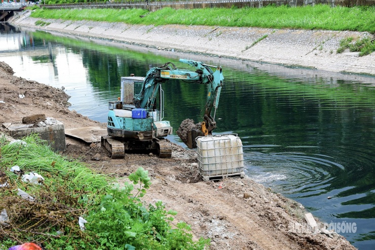 Máy móc hoạt động liên tục bên bờ sông Tô Lịch – nơi đang được cải tạo để trở thành không gian xanh cho người dân Thủ đô.