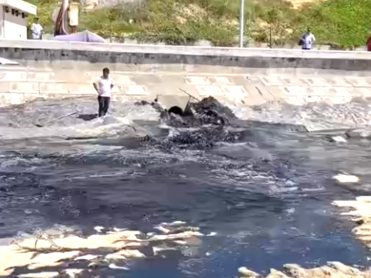 Nước thải có màu đen kịt từ cống thoát nước đổ ra bờ biển. Ảnh cắt từ clip