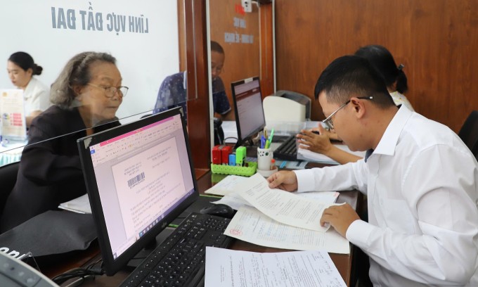  Cán bộ Trung tâm phục vụ hành chính công phường Thới  An giải quyết hồ sơ của bà Ngô Thành Lợi Thơ, ngày 14/7. Ảnh: Lê Tuyết  