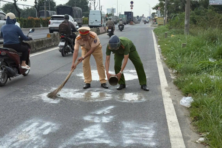 Cơ quan chức năng xử lý vết sơn trên mặt đường. Ảnh: CSGT TPHCM.
