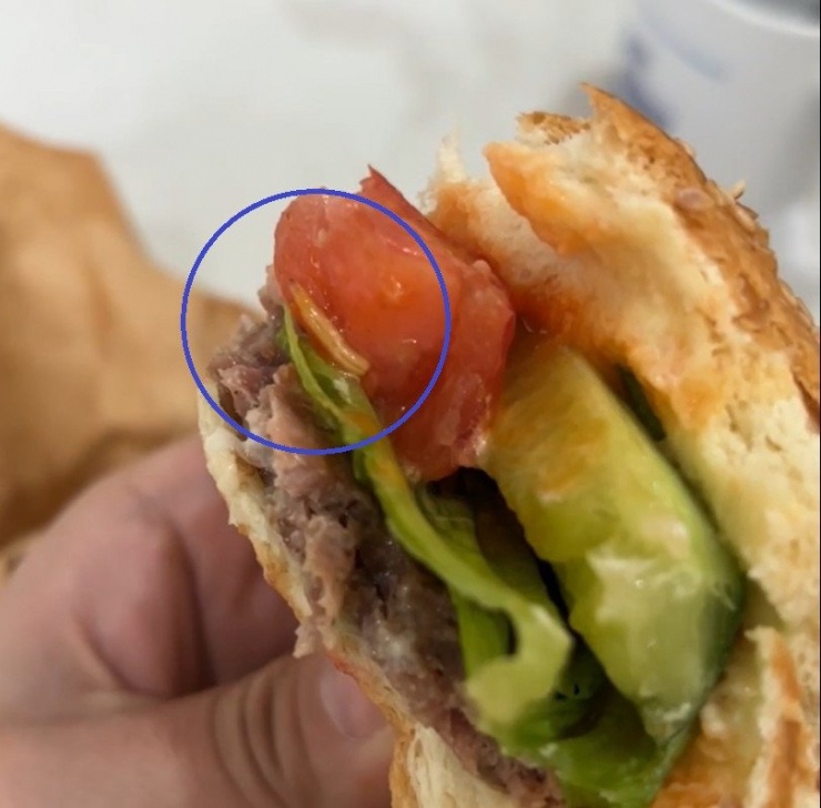 Dòi bò trong phần bánh hamburger được người dân phát hiện. Ảnh: Chụp màn hình