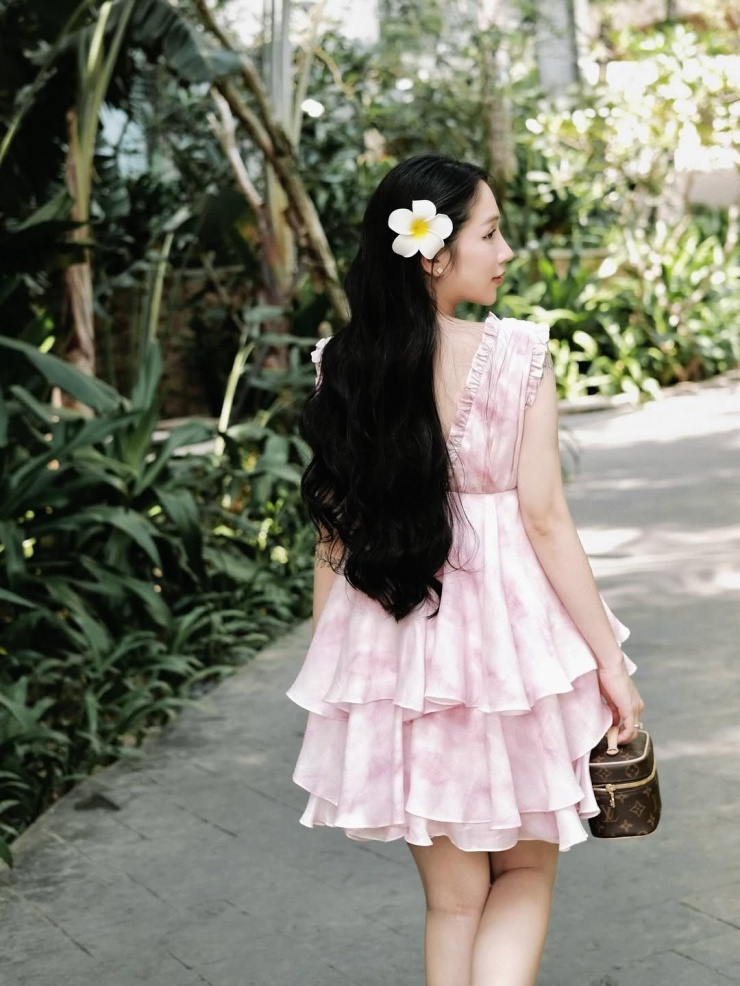 Một chiếc váy hồng pastel xếp tầng điệu đà, kết hợp với túi xách nhỏ xinh tạo nên vẻ ngoài ngọt ngào, nữ tính.