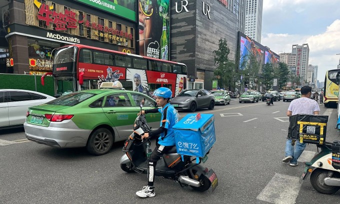Một tài xế giao hàng bằng xe điện hai bánh ở Thành Đô, Trung Quốc ngày 28/5. Ảnh: Phiên An