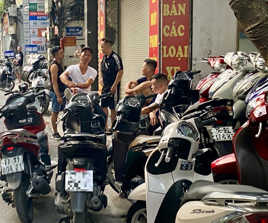 Chủ các cửa hàng tụm lại nói chuyện để bớt buồn chán.