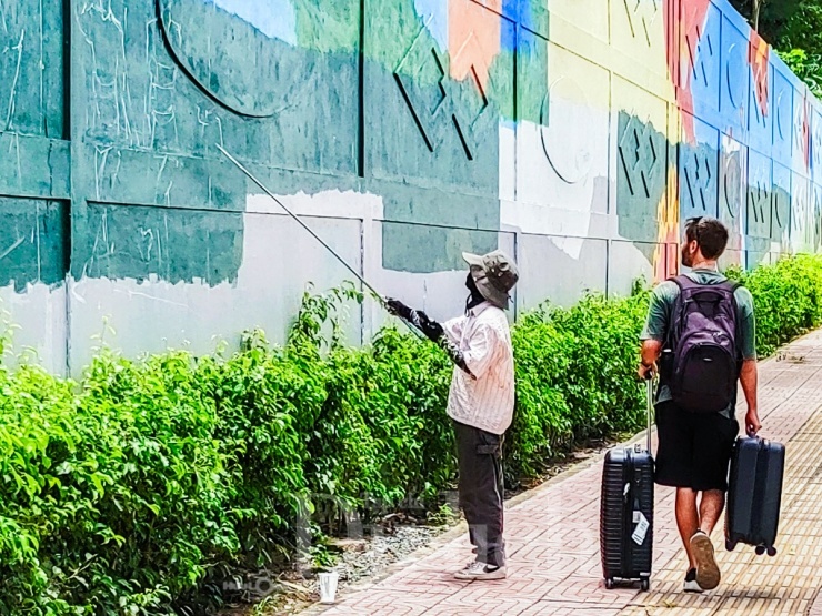 Anh Mark Johnson say sưa dõi theo người họa sĩ đang cần mẫn tô điểm cho "cuốn phim" lịch sử rực rỡ sắc màu đang dần hình thành.