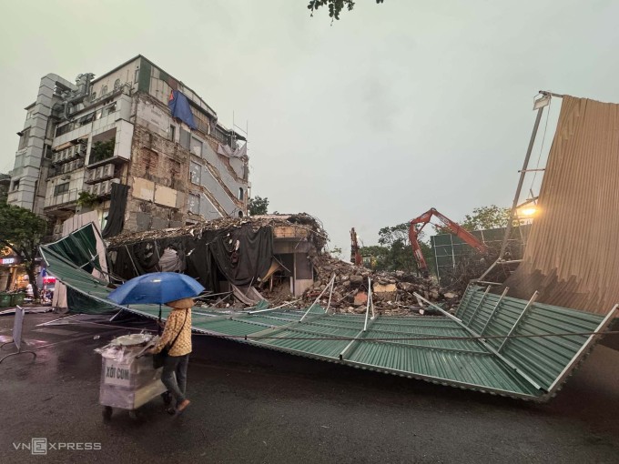 Hàng rào tôn quây quanh tòa "Hàm cá mập" bị gió quật đổ. Ảnh: Giang Huy