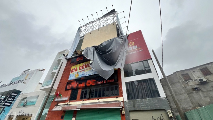 Biển quảng cáo trên đường Cách Mạng Tháng Tám rách tả tơi sau cơn giông. Ảnh: Minh Hoàng