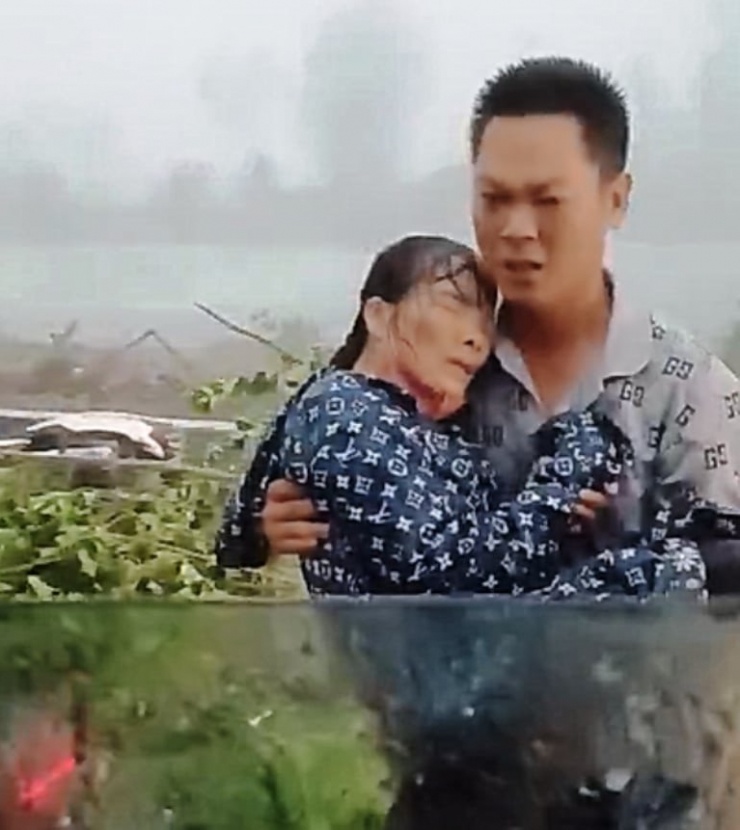 Anh Hiệp bế người phụ nữ đưa vào xe đi cấp cứu (Ảnh: Cắt từ clip)