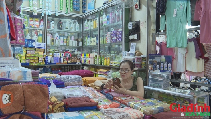 Nhiều tiểu thương ngồi không, lướt điện thoại hoặc chơi game để giết thời gian.