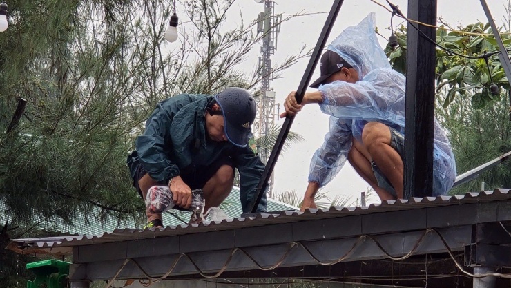 Nhiều hộ dân ở dọc bãi biển khu 2, khu 1 bắt vít gia cố mái tôn.