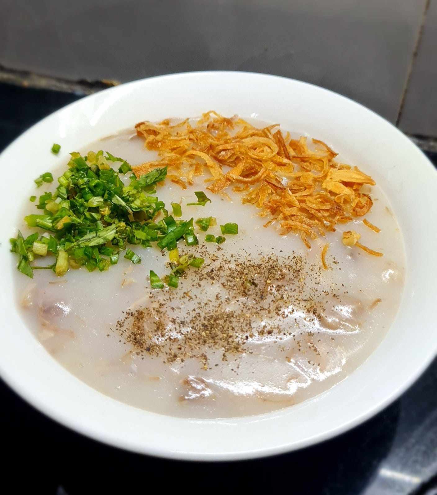 Múc cháo ra bát, thêm hành phi, hành tươi và tiêu xay. Cháo sườn nấu theo cách này có độ sánh quyện, sườn mềm ngọt, đậm đà vô cùng hấp dẫn.