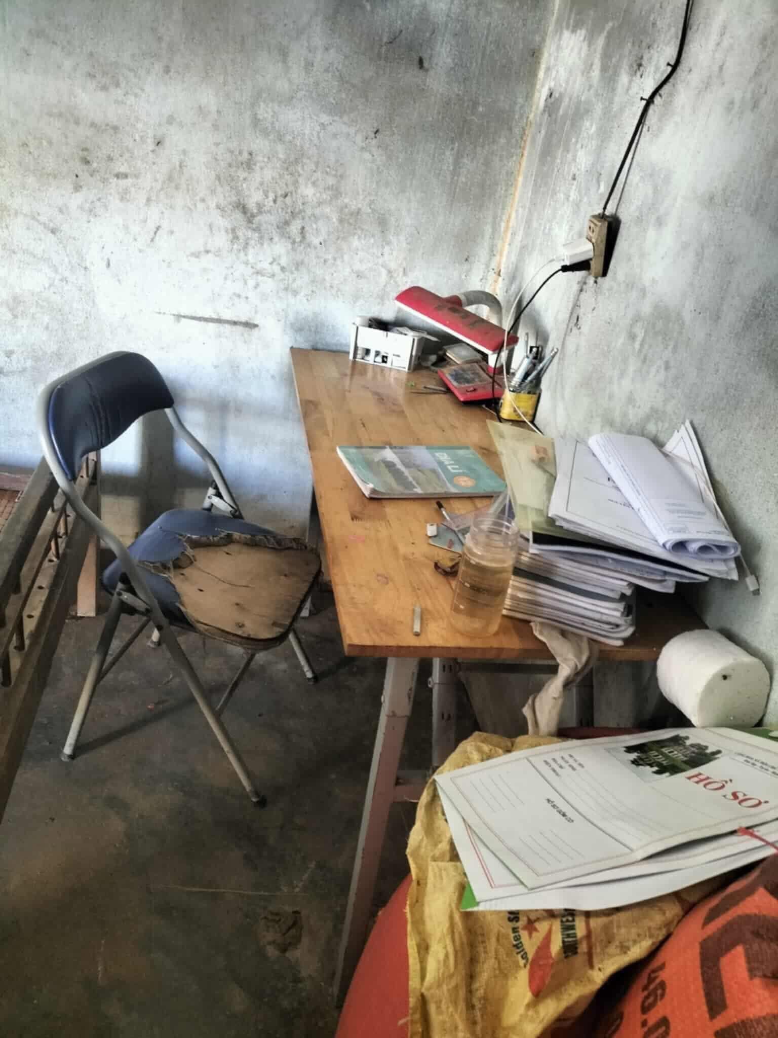 Bộ bàn ghế học tập của em được người khác cho dùng lại. Cạnh bàn học là những tập hồ sơ em chuẩn bị để nộp vào làm công nhân.