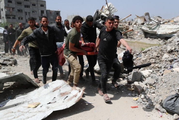 Người dân Gaza đưa người bị thương vì hỏa lực Israel ra khỏi một đống đổ nát. Ảnh: Reuters
