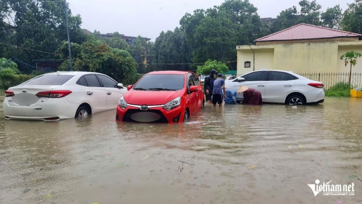 Chủ phương tiện dùng kích kê cao xe lên nhằm tránh ngập nước. Ảnh: Lê Dương